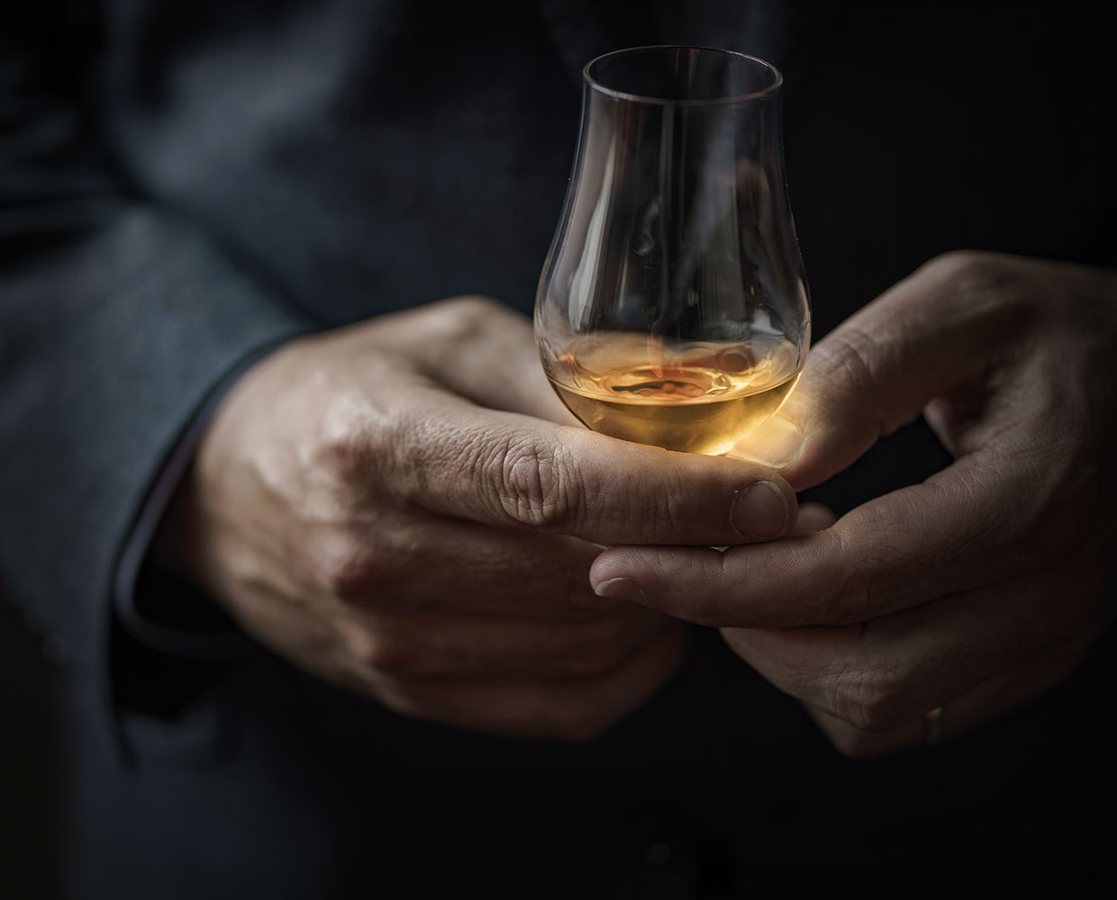 Close up of hands holding glass.